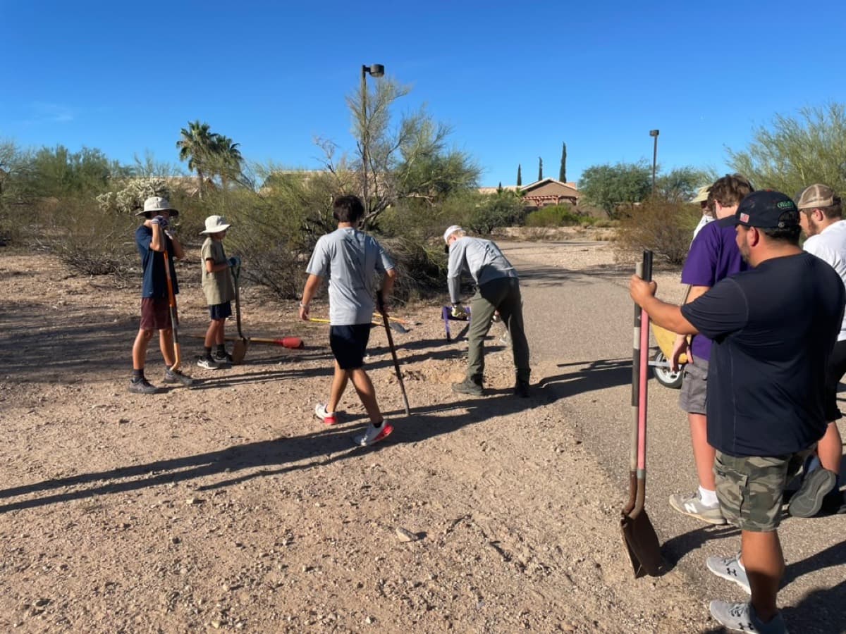 Scout troop working on the Purple Heart Park trail with shovels and tools.